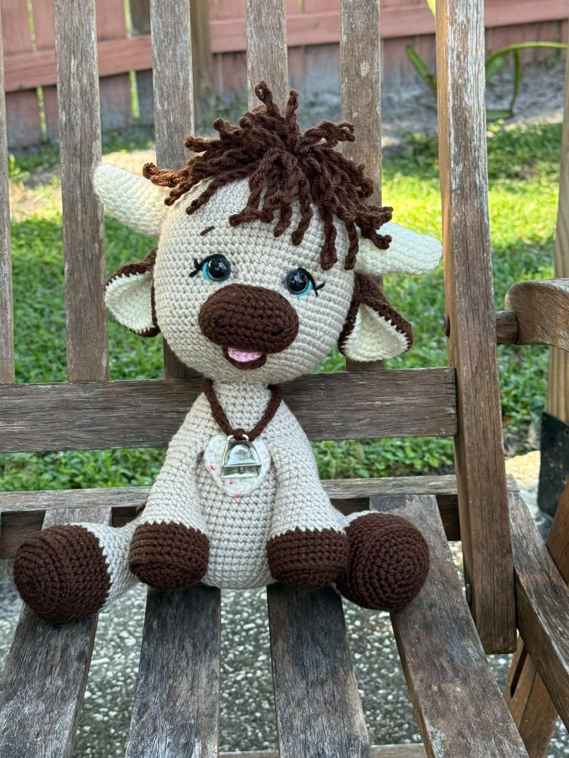 Cream and chocolate tester-made Olly sitting on a rustic wooden bench outdoors