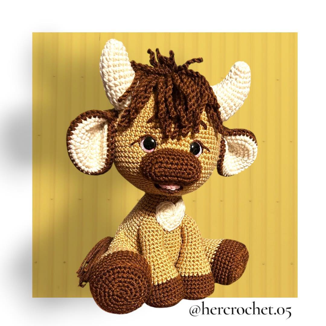 Golden brown tester-made Olly with cream horns and a white heart against a yellow background