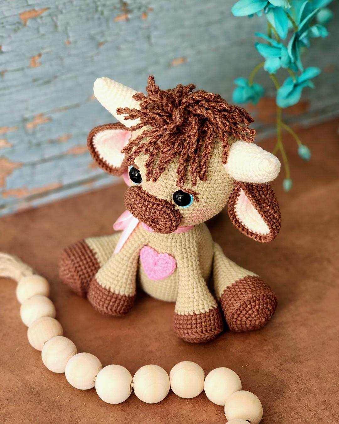 Tester-made Olly sitting beside a curved strand of wooden beads